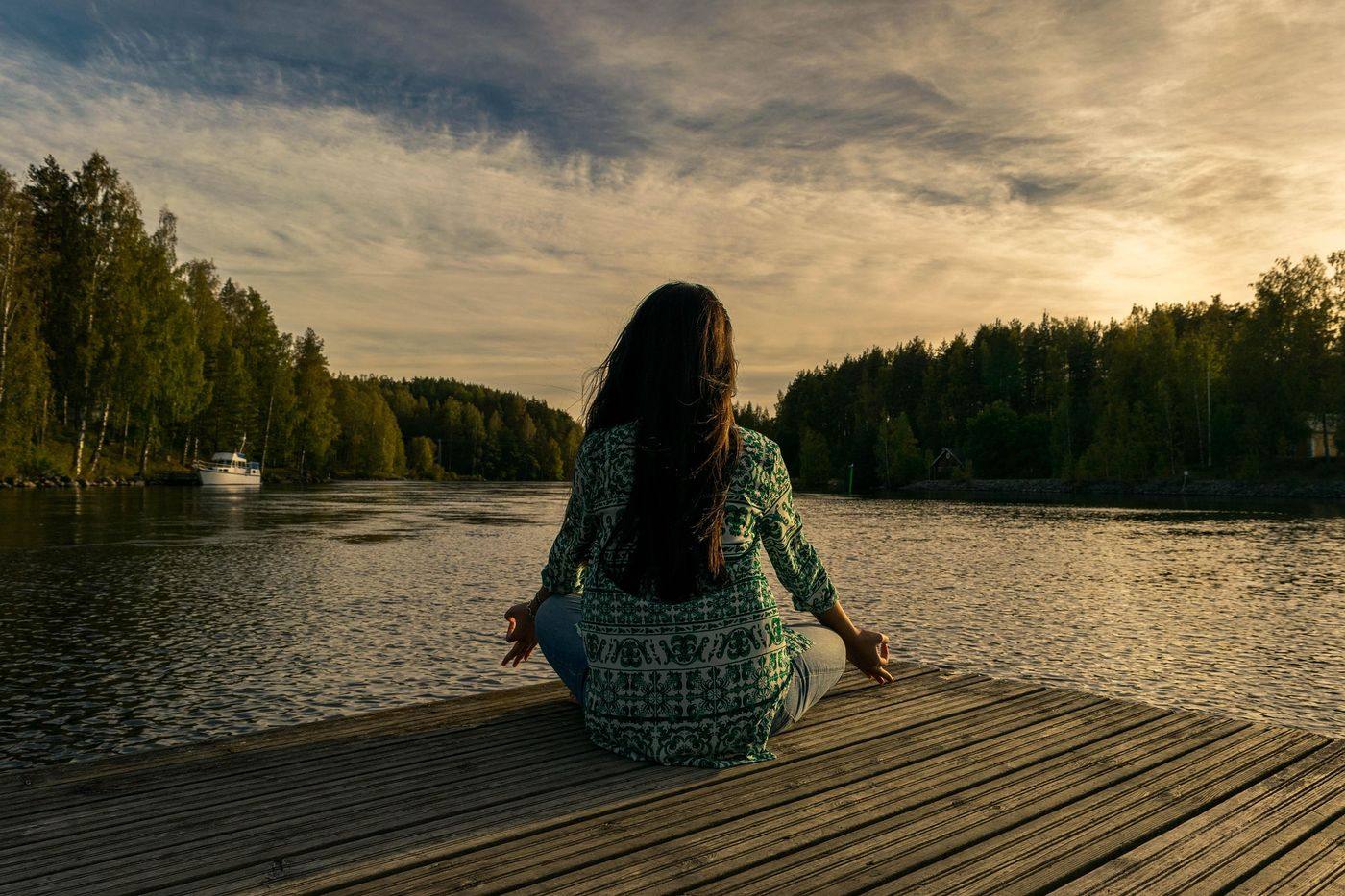 Femme en méditation au bord de l'eau, ambiance L'Enquête Intérieure